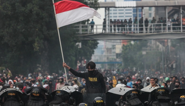 A protester raises the Indonesian flag during the Omnibus Law protest / TEMPO/Hilman Fathurrahman